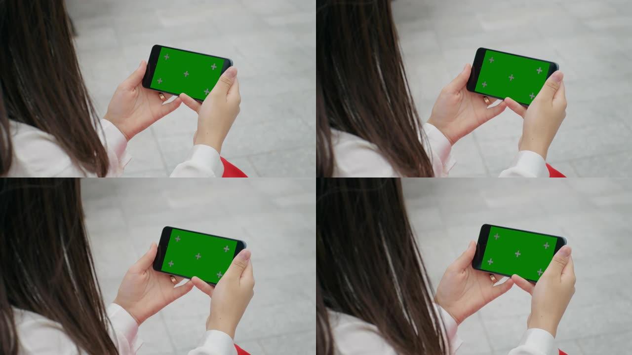 女性手在智能手机上观看色度键屏幕。
