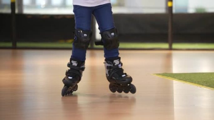 亚洲男孩只是练习玩旱冰鞋，室内直排轮滑
