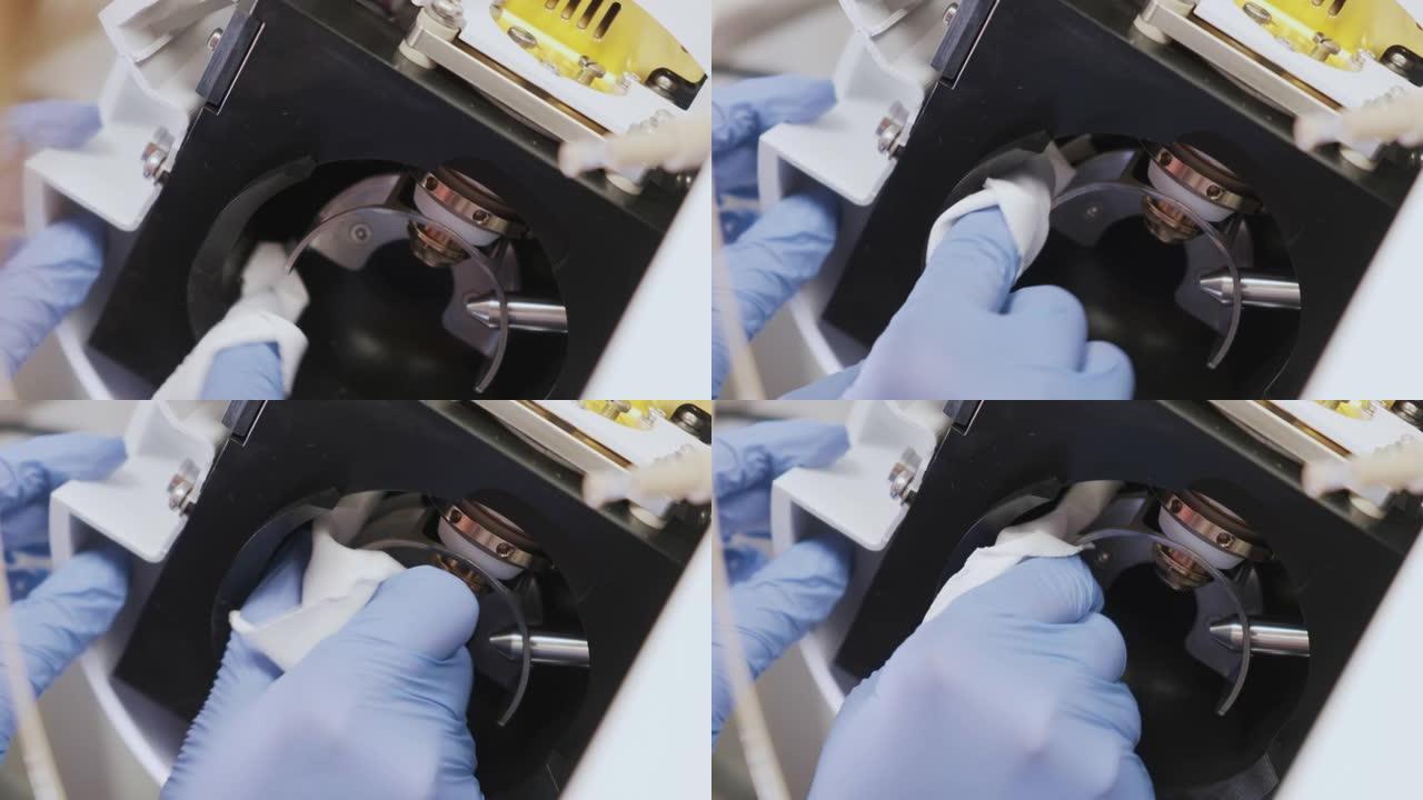 关闭科学家用无绒布和溶剂清洁质谱仪的离子源。LC Ms qTOF系统的维护或清洁。分析实验室常规