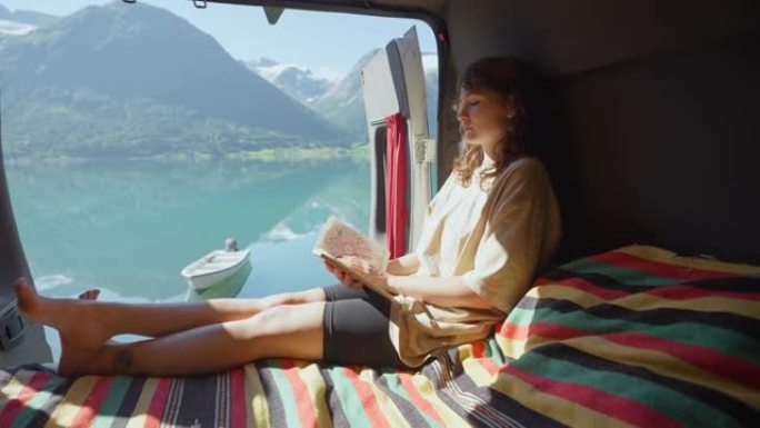 女人坐在露营车上看书