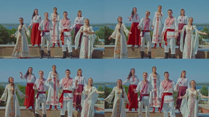 乌克兰人站在公园里唱歌，用刺绣的美丽民间服装。乌克兰男人和女人享受生活，他们微笑。友好的人。4k，普