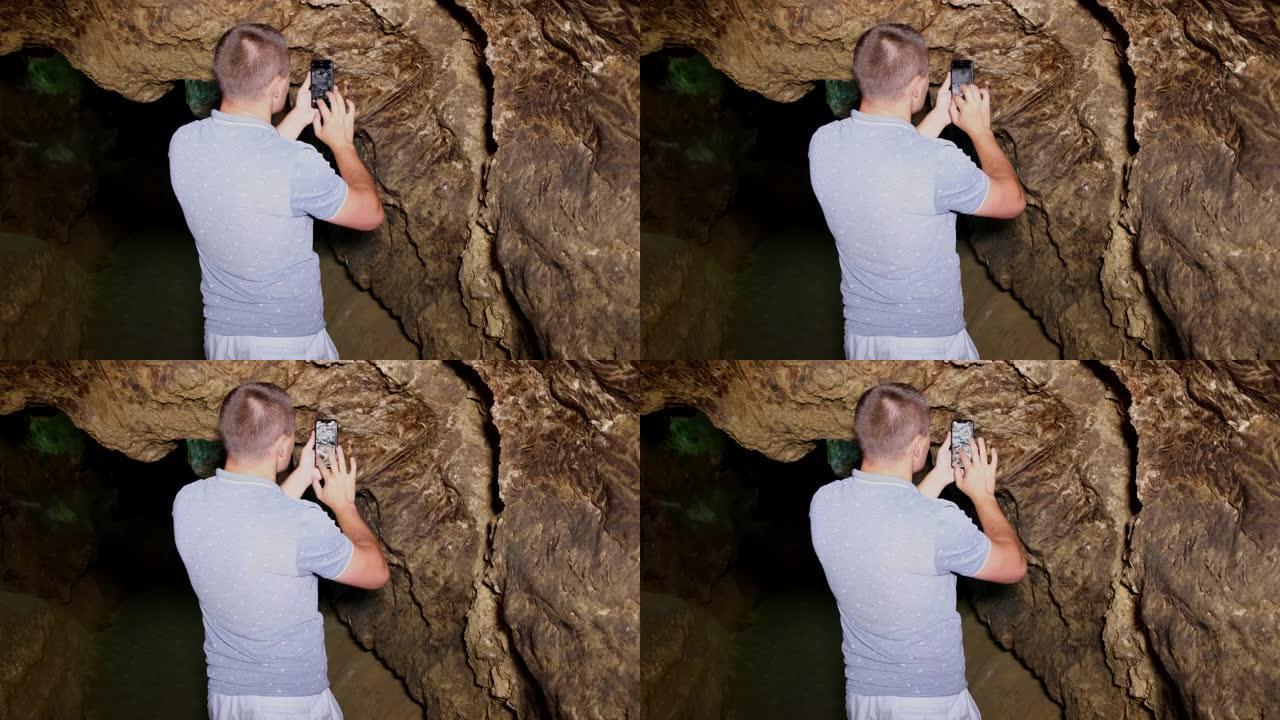盖伊游客在地牢里给洞穴拍照。