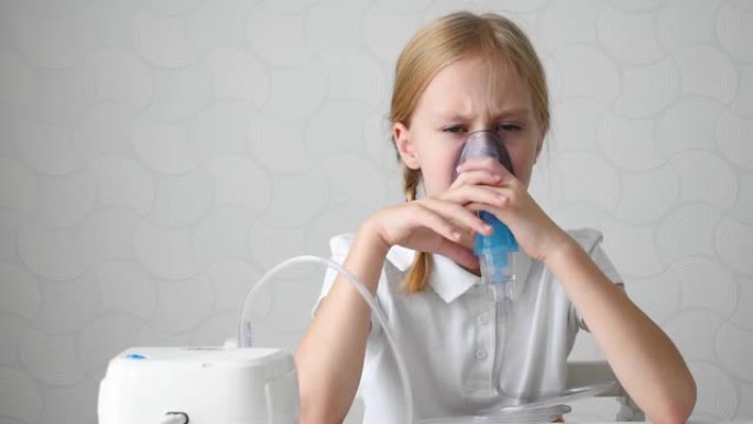 一个小女孩的特写镜头用医用雾化器吸入并咳嗽