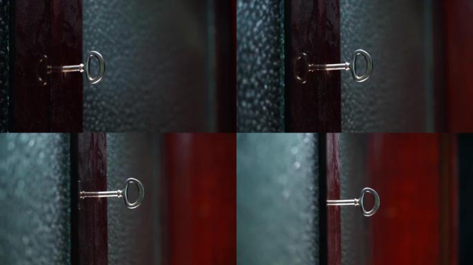 闪亮的复古钥匙插入餐具柜门，透明窗户在模糊背景上特写