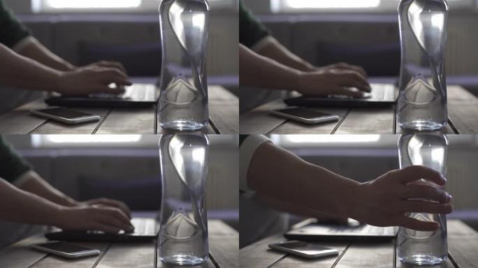 使用笔记本电脑的人正在喝水