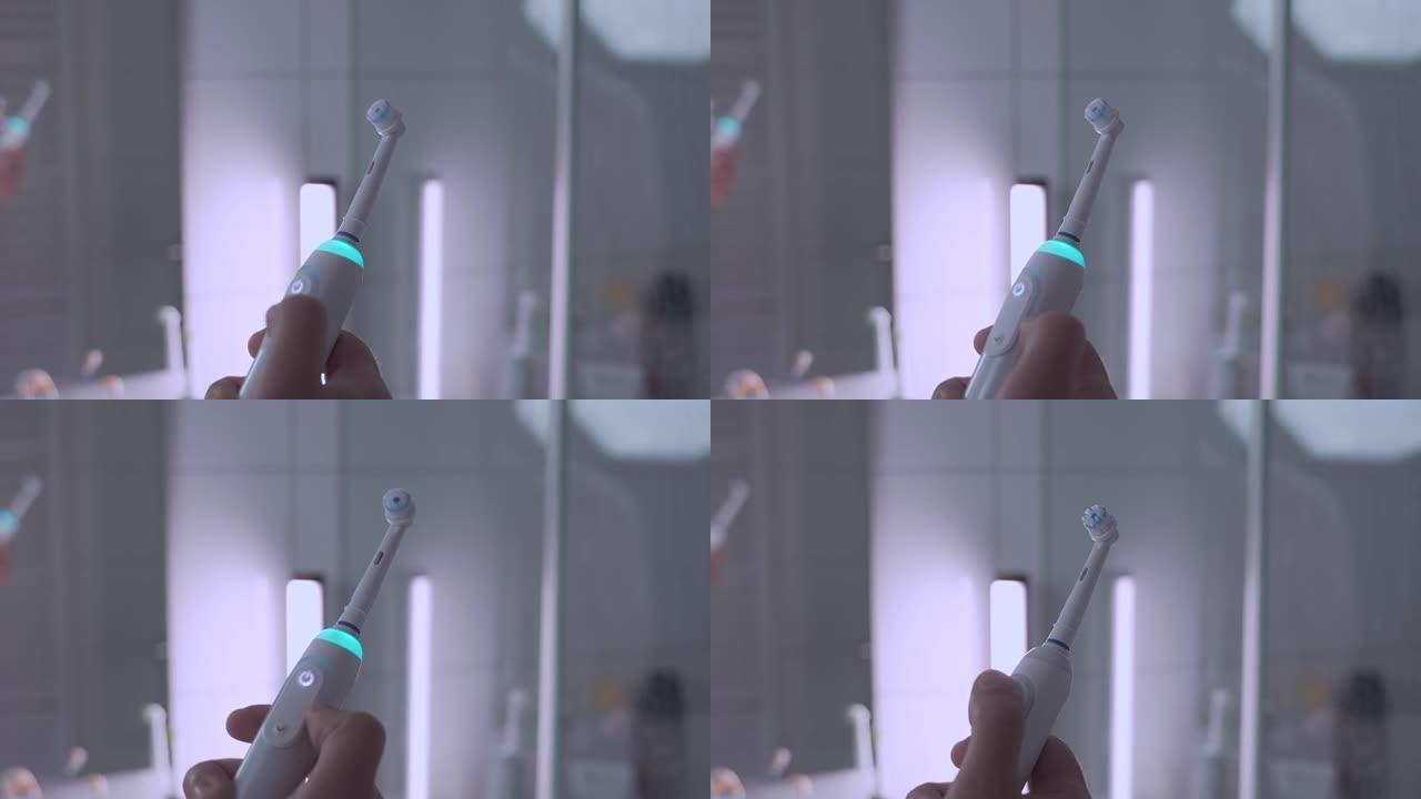 男性手的特写打开和关闭白色超声波牙刷，浴室背景为蓝色背光。口腔护理和洁白的牙齿。电动牙刷。牙科清洁器