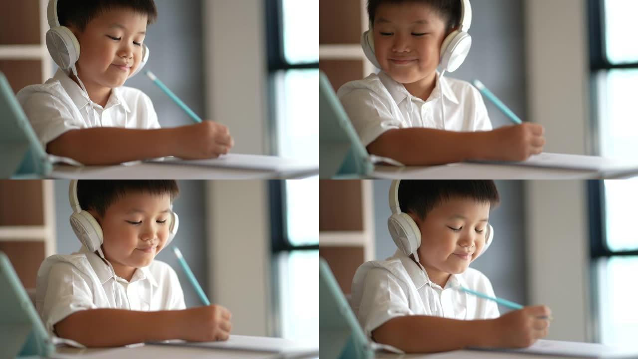 亚洲孩子用耳机学习在线学习。新常态的概念研究与检疫