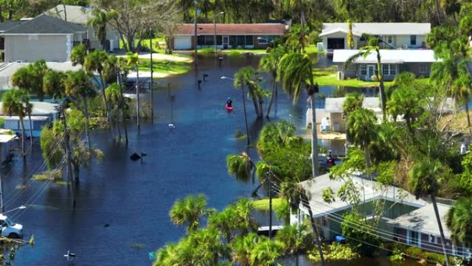 漂浮在被飓风伊恩·降雨包围的洪水街道上的皮划艇在佛罗里达州居民区的洪水房屋中。自然灾害的后果
