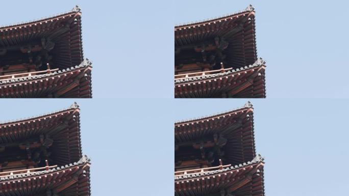 青铜钟在中国传统木塔上随风摇曳，背景为蓝天，4k慢动作镜头，低角度特写。