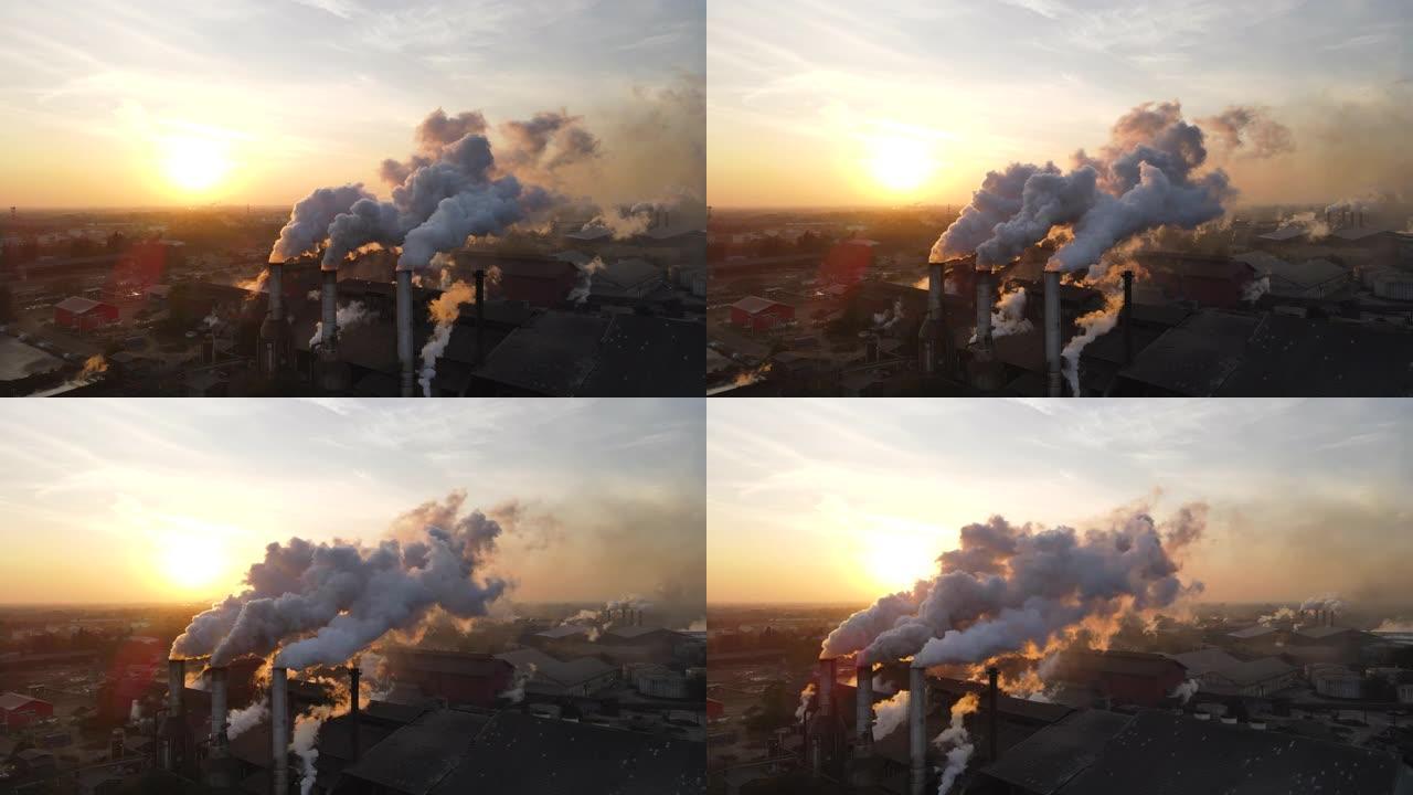 日出时工厂烟囱冒烟的鸟瞰图
