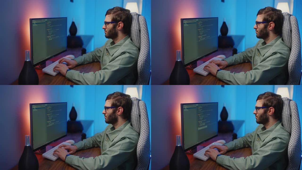 戴眼镜的男性程序员看着显示器，在键盘上打字，创建程序或应用程序。互联网产品开发者数据科学家