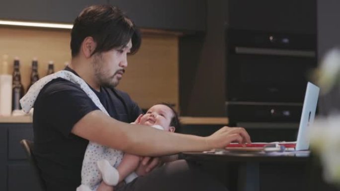 父亲抱着女婴工作父亲抱着女婴工作