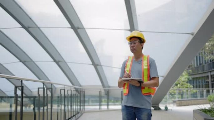 土木建筑工程师正在站立并使用平板电脑检查生产中使用的建筑材料的施工是否符合标准。结构架构数据验证技术