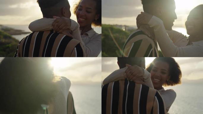 日落时的浪漫约会。两个非洲族裔青少年互相拥抱。男朋友把女朋友抬起来。年轻的爱
