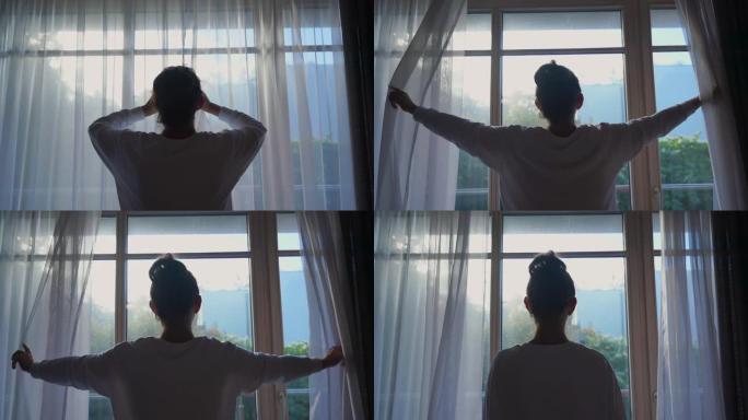女人用手推开悬挂在窗户上的白色窗帘