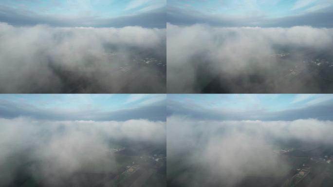 在低空的云层中飞行。从飞机驾驶舱看，滑翔机。