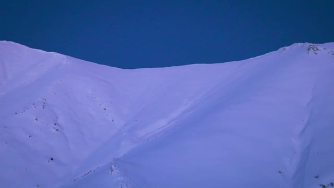 深蓝色夜空下风景秀丽的冰雪覆盖的山脉