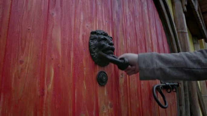 狮子头敲门形状的锻铁门把手。霍比特人圆门。慢动作。