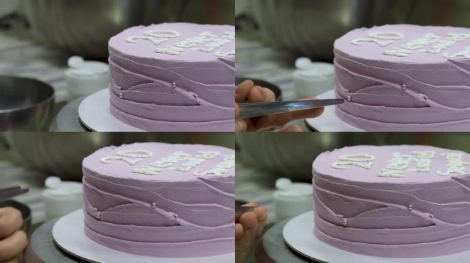 糕点师装饰紫色磨砂生日蛋糕，上面印有文字，撒上，珍珠和蝴蝶。