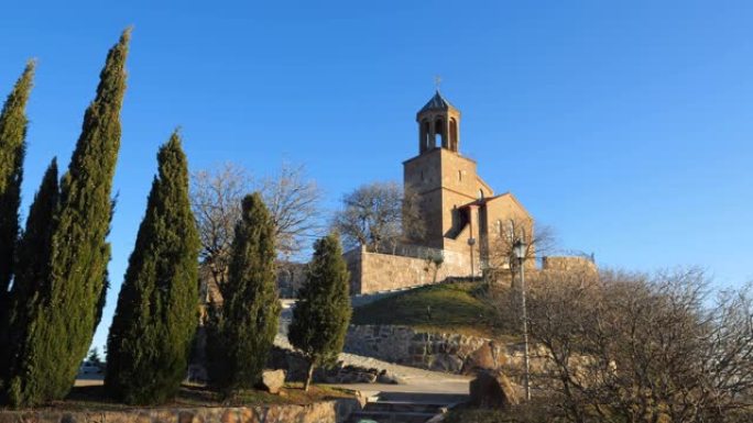 格鲁吉亚。沙夫纳巴达修道院，在第比利斯郊区的沙夫纳巴达山顶上有圣乔治教堂。前景是修道院的墙壁，背景是