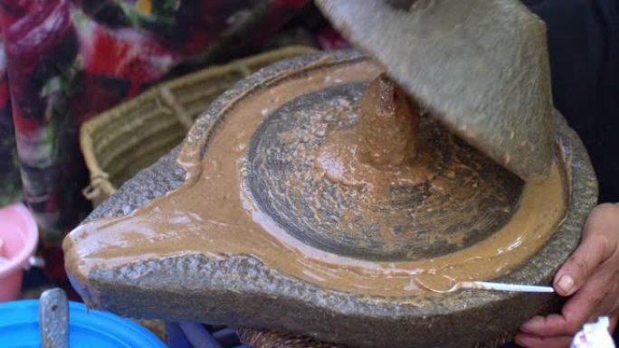 摩洛哥柏柏尔妇女在石制手工磨磨摩洛哥坚果油研磨杏仁