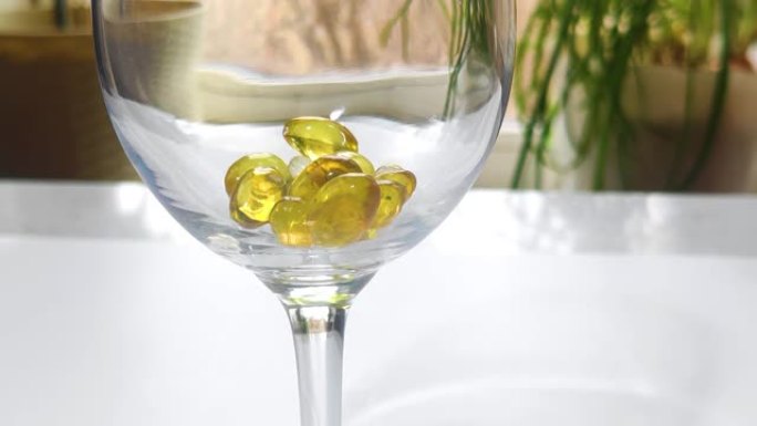 金色药丸欧米茄3落在玻璃药物保健概念白色背景特写分散