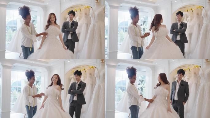 女婚店老板帮助新娘和新郎在婚礼工作室挑选和试穿婚纱