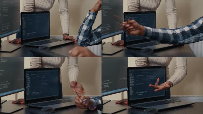 笔记本电脑运行算法的特写在做团队工作的程序员面前在桌子上解析代码