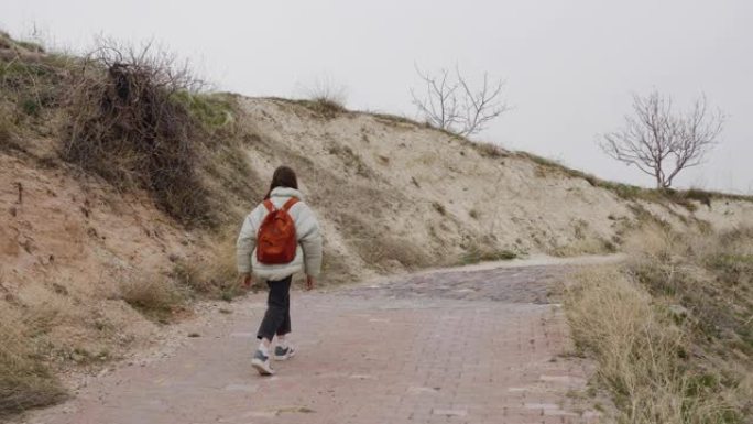 十几岁的女孩背着背包在山中徒步旅行