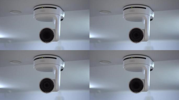 遥控相机使用机电光学变焦。房间天花板上挂着一台白色照相机。用于流媒体和视频录制的摄像机。4k