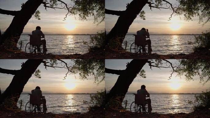 男人坐在轮椅上，有一天的第一个金色日出。有希望的残疾人。
