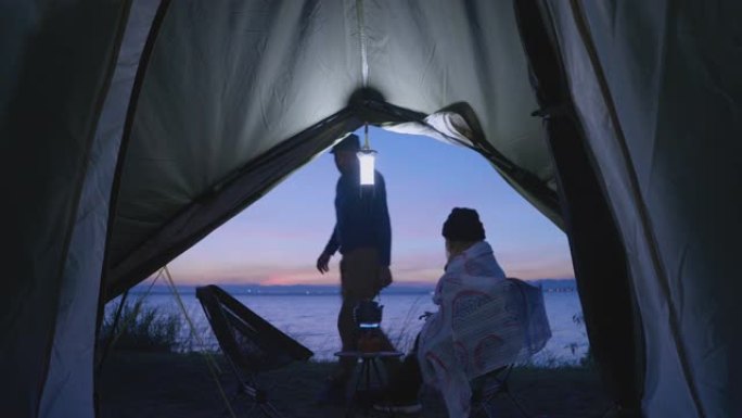 男性被盖毯子一名女子早上露营喝咖啡
