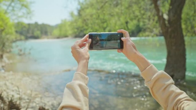 科普鲁鲁峡谷山河岸上的女游客获得全景照片。Koprulu峡谷是土耳其常见的旅游胜地。女孩用手机相机拍