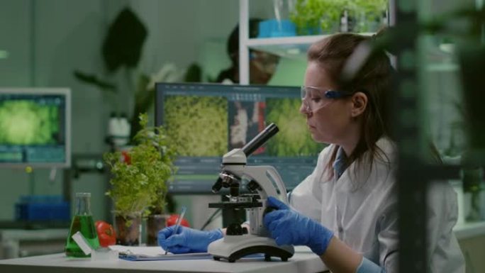 制药科学家在显微镜下观察绿叶样品