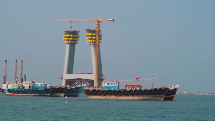 海中的船只在印度古吉拉特邦Okha和Beyt Dwarka之间正在建造的标志性电缆桥前移动
