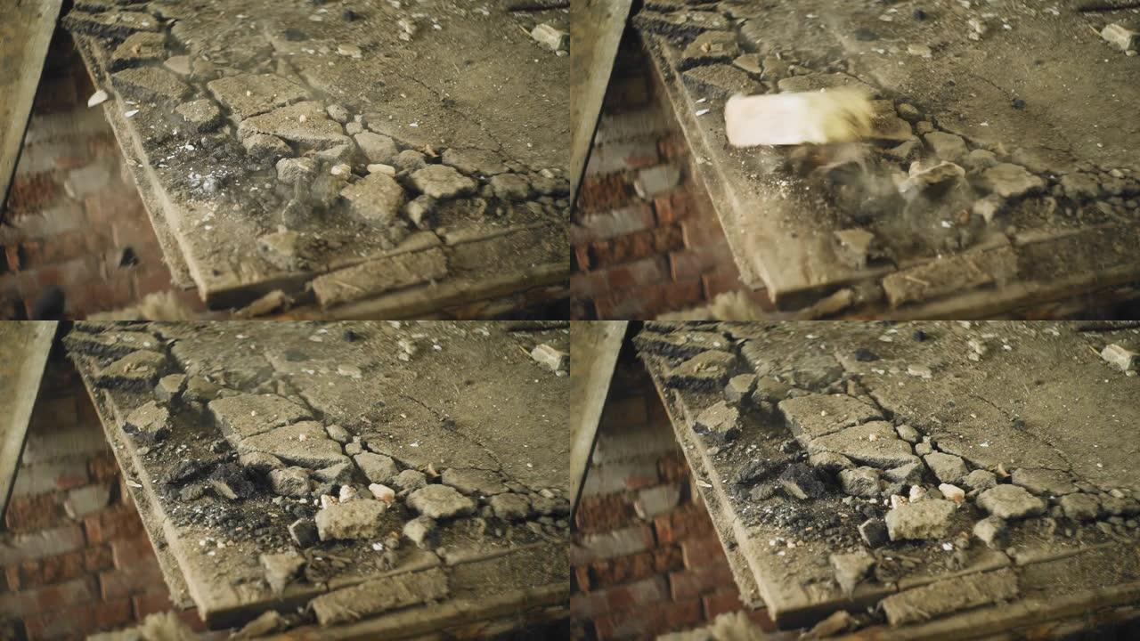 在一栋旧建筑中，一块砖掉到地板上，从旧木板上扬起灰尘。建筑物的破坏过程