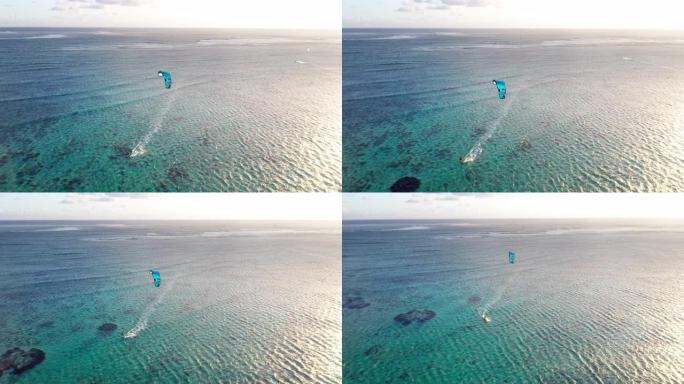 4k镜头日落时间无人机飞越宁静的珊瑚礁湾，风筝冲浪者骑着风筝冲浪板。活跃的运动人和大自然中的美概念航
