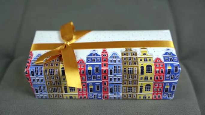 礼物装在一个漂亮的包装纸上的盒子里，上面系着一条带蝴蝶结的丝带