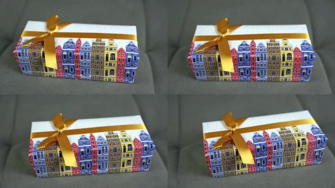 礼物装在一个漂亮的包装纸上的盒子里，上面系着一条带蝴蝶结的丝带