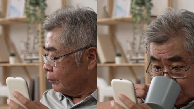竖屏: 老人用手机看网络新闻，喝咖啡。老白发爷爷用手机享受一杯早茶。