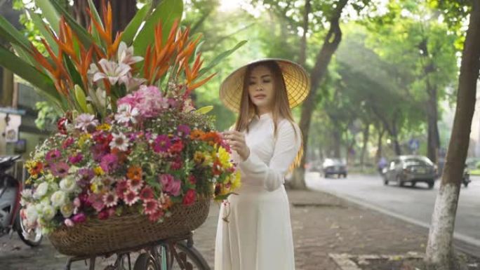 骑自行车和鲜花的亚洲小贩的肖像，越南女女孩在越南河内城市城镇旅行。人们的生活方式。