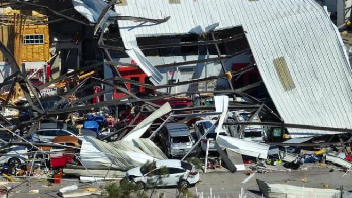 飓风伊恩摧毁了佛罗里达州废墟下损坏的汽车的工业建筑。自然灾害及其后果