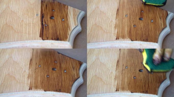 用软海绵、翻新和木工概念对木板表面进行涂漆，木匠用棕色油漆涂覆修复的木板