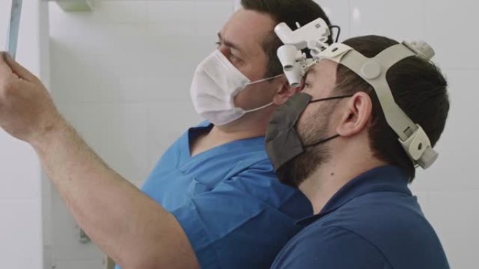 两名牙医的脸部特写正在检查x射线。为病人治疗做准备。医学与健康