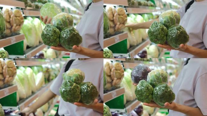 一个女人正在购买新鲜蔬菜，绿色西兰花和花椰菜。在蔬菜部门购买新鲜的白菜，为全家人准备一顿健康的饭菜。