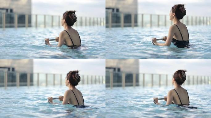 积极健康的生活方式高净值亚洲女性在豪华游泳池享受她的一天