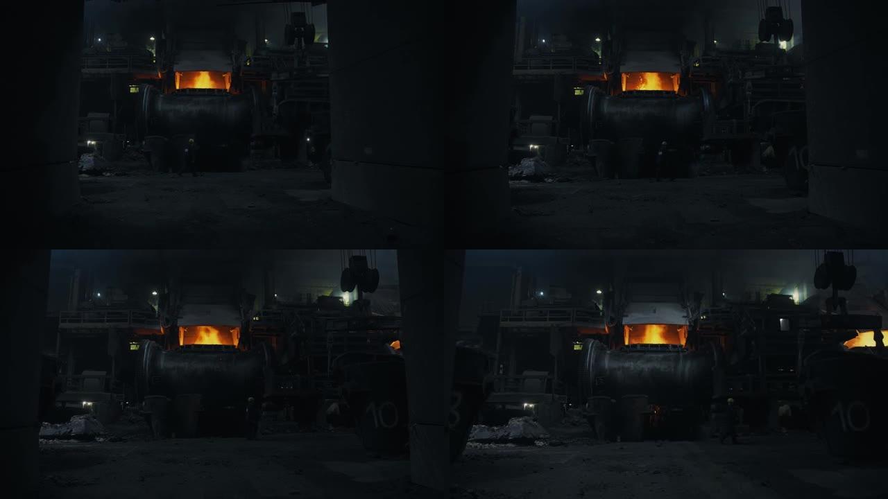 大型冶金炉。明亮的火焰在里面燃烧。一个人走过炉子。冶金厂。钢材制造.4k