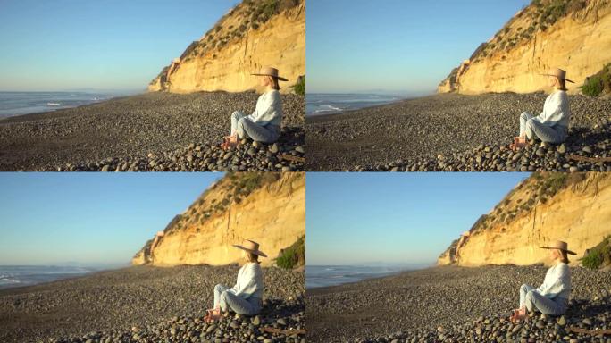 年轻的拉丁裔妇女在空旷的卵石海滩上享受孤独