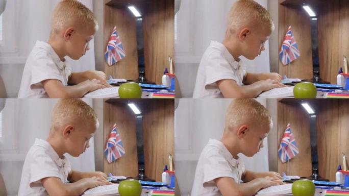 一个悲伤的小男孩在餐桌上在家看书的特写镜头。作业。