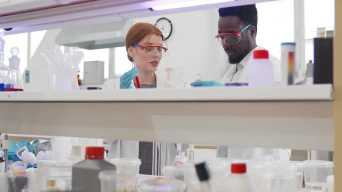 多样化的年轻科学家在实验室中拿着带有样品开发疫苗的试管